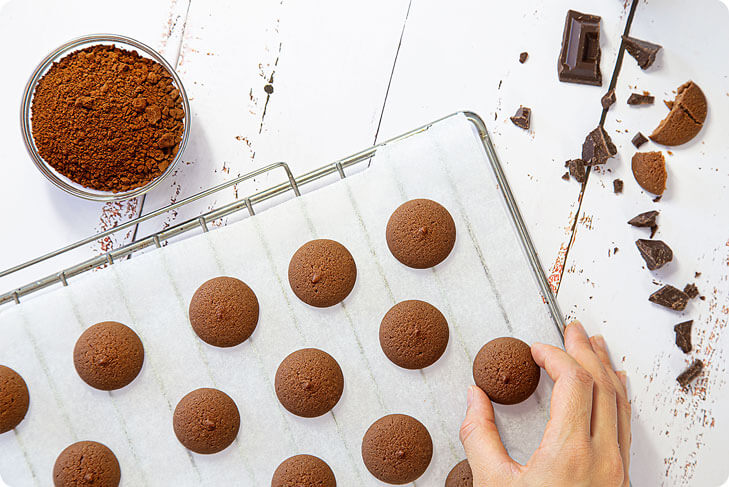 Bottoncini proteici al cacao su una griglia mano che li afferra