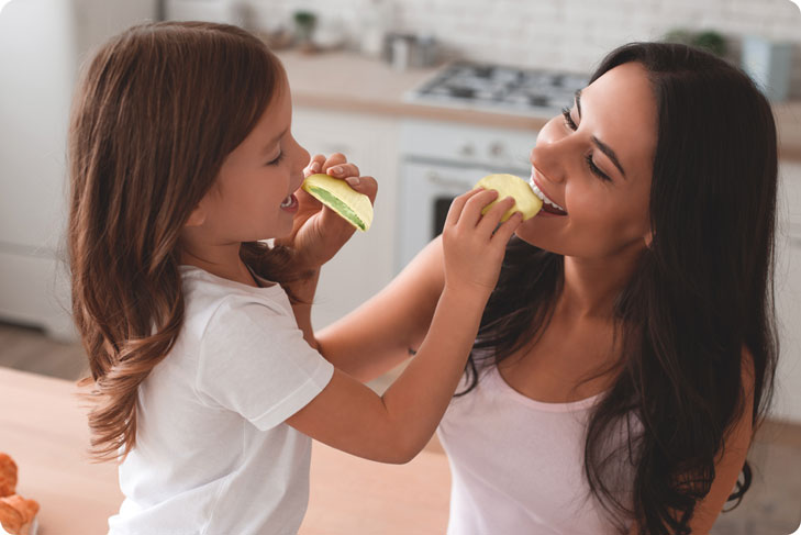 Mamma e figlia che mangiano il medaglione ricoperto di cioccolato