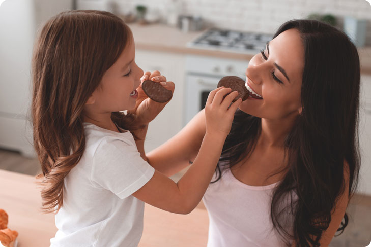 Mamma e figlia che mangiano il medaglione ricoperto di cioccolato