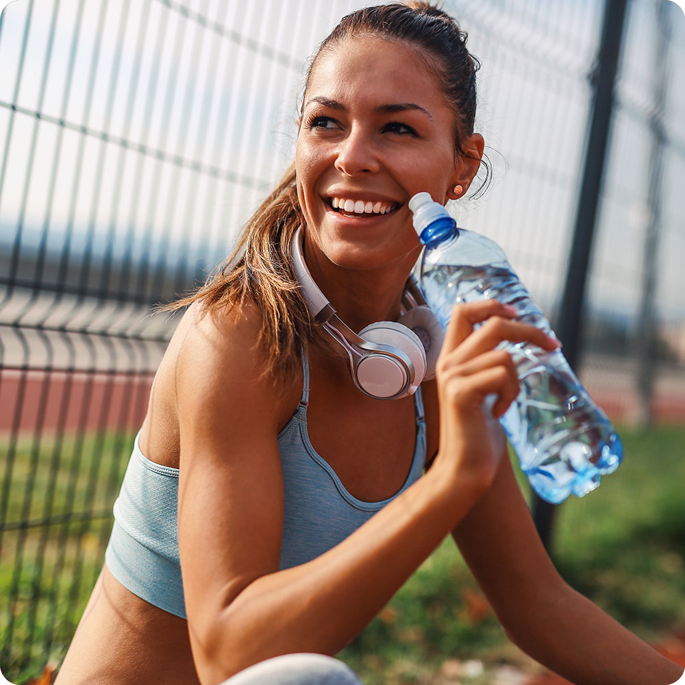 Ragazza che si idrata dopo aver fatto jogging 